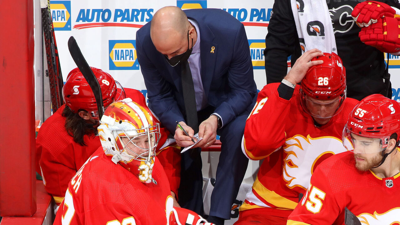CALGARY, ALBERTA - MARCH 27: Assistant Coach Ryan Huska instructs Chris Tanev #8 of the Calgary Flames during the game against the Winnipeg Jets at Scotiabank Saddledome on March 27, 2021 in Calgary, Alberta.
