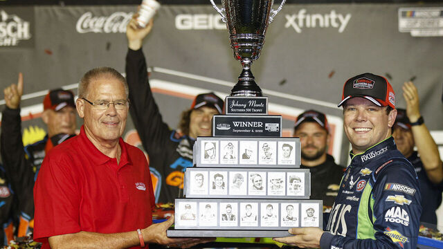DARLINGTON, SOUTH CAROLINA - SEPTEMBER 04: Erik Jones, driver of the #43 FOCUSfactor Chevrolet, receives the Johnny Mantz Southern 500 trophy from Kerry Tharp, Darlington Raceway President in victory lane after winning he NASCAR Cup Series Cook Out Southern 500 at Darlington Raceway on September 04, 2022 in Darlington, South Carolina.