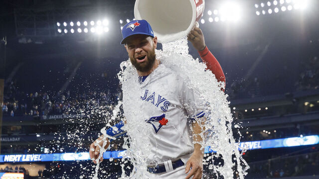 TORONTO, CANADA - JUNE 7: Vladimir Guerrero Jr. #27 of the Toronto Blue Jays pours an ice bath on Brandon Belt #13 during his post-game interview following their MLB game against the Houston Astros at Rogers Centre on June 7, 2023 in Toronto, Canada.