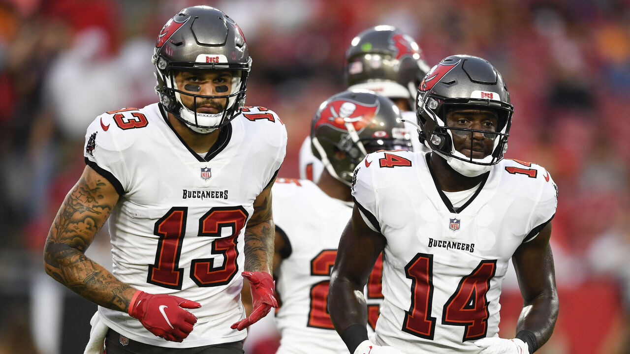 TAMPA, FLORIDA - AUGUST 14: Mike Evans #13 and Chris Godwin #14 of the Tampa Bay Buccaneers break from the huddle during the first quarter against the Cincinnati Bengals during a preseason game at Raymond James Stadium on August 14, 2021 in Tampa, Florida.