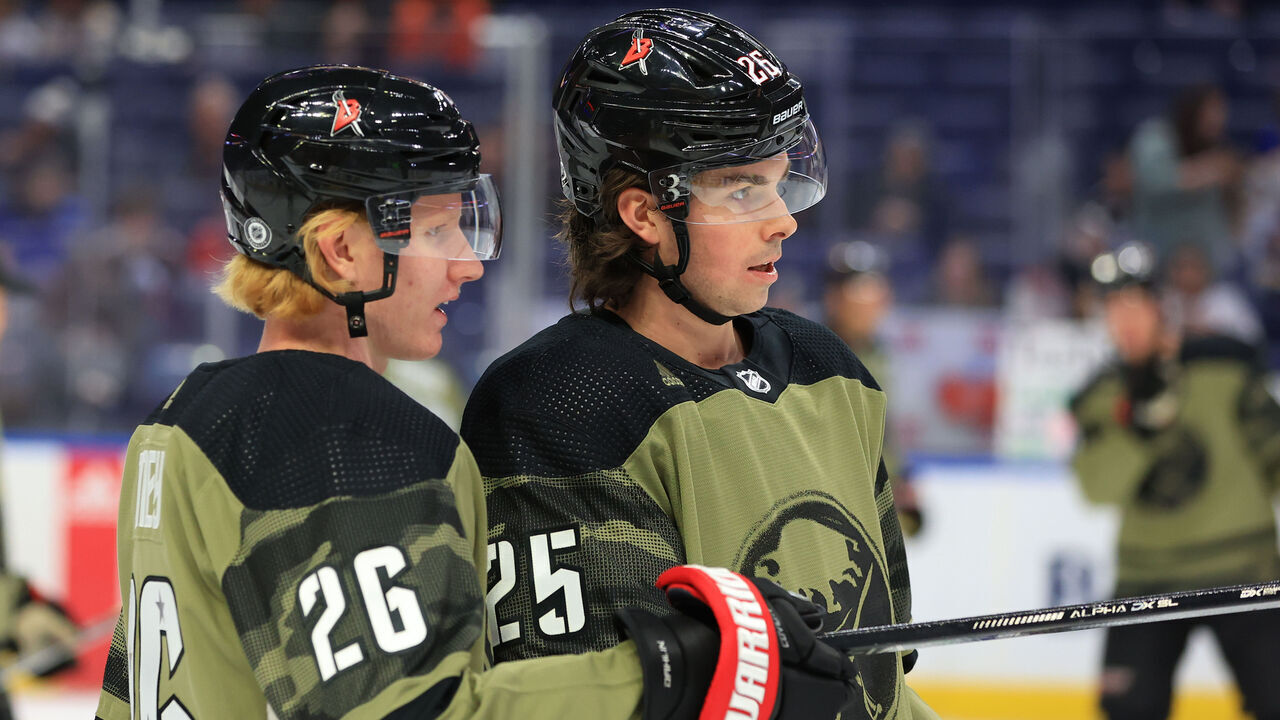 BUFFALO, NY - MARCH 24: Rasmus Dahlin #26 and Owen Power #25 of the Buffalo Sabres chat wearing special warmup jerseys for Military Appreciation Night, prior to an NHL game against the New Jersey Devils on March 24, 2023 at KeyBank Center in Buffalo, New York.