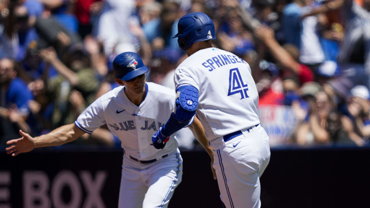 TORONTO, ON - JUNE 25: George Springer #4 of the Toronto Blue Jays celebrates his home run against the Oakland Athletics with Mark Budzinski #53 during the first inning in their MLB game at the Rogers Centre on June 25, 2023 in Toronto, Canada.
