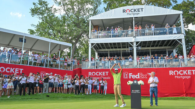DETROIT, MI - JULY 31: Tony Finau raises the trophy on the 18th green during the trophy ceremony after the final round of the Rocket Mortgage Classic at Detroit Golf Club on July 31, 2022 in Detroit, Michigan.