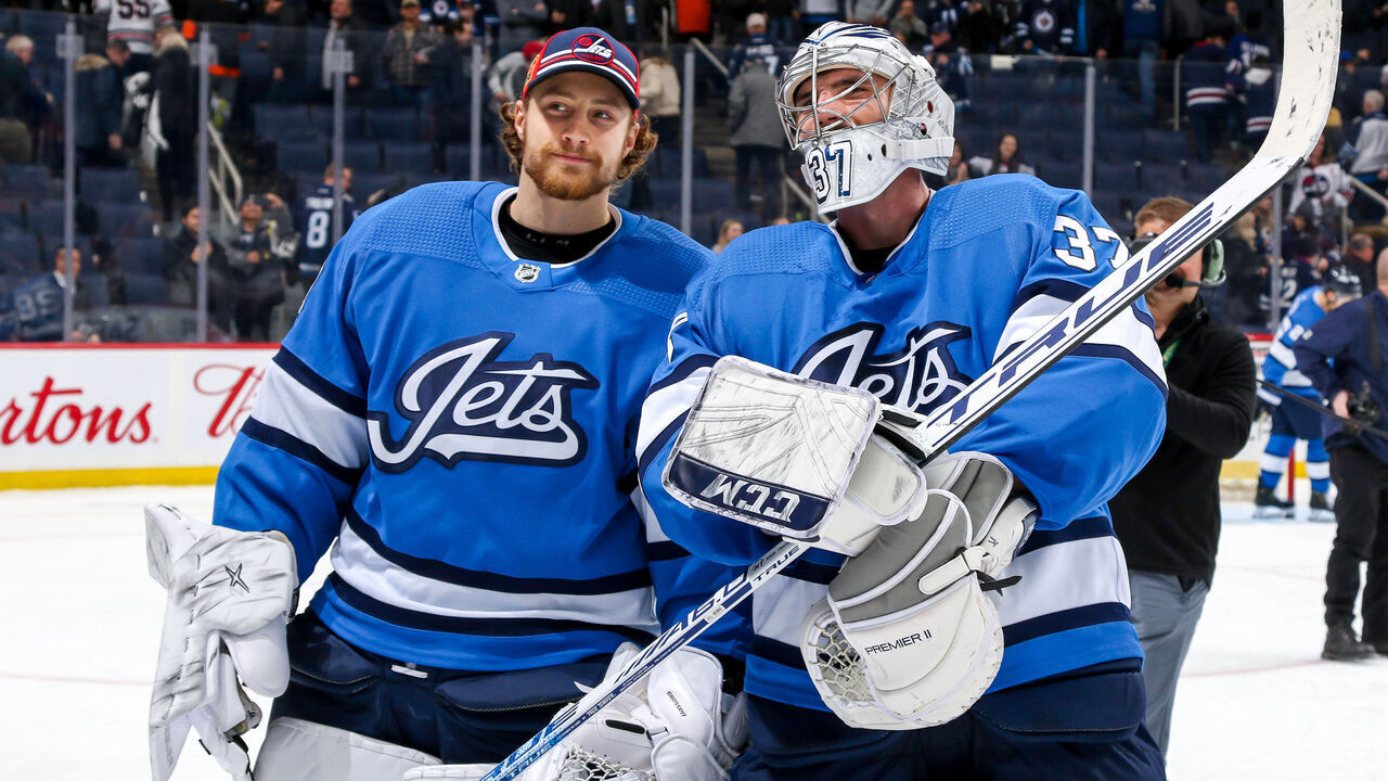 WINNIPEG, MB - DECEMBER 15: Goaltenders Laurent Brossoit #30 and Connor Hellebuyck #37 of the Winnipeg Jets are all smiles as they leave the ice following a 7-3 victory over the Philadelphia Flyers at the Bell MTS Place on December 15, 2019 in Winnipeg, Manitoba, Canada.
