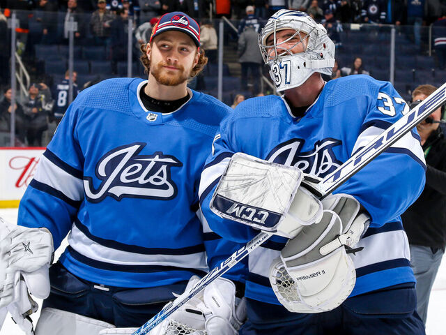 WINNIPEG, MB - DECEMBER 15: Goaltenders Laurent Brossoit #30 and Connor Hellebuyck #37 of the Winnipeg Jets are all smiles as they leave the ice following a 7-3 victory over the Philadelphia Flyers at the Bell MTS Place on December 15, 2019 in Winnipeg, Manitoba, Canada.