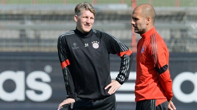 Bayern Munich's midfielder Bastian Schweinsteiger (L) and Bayern Munich's Spanish headcoach Pep Guardiola take part in a training session in Munich, southern Germany on April 20, 2015, on the eve of the UEFA Champions League quarter-final second-leg football match Bayern Munich v FC Porto. AFP PHOTO / CHRISTOF STACHE