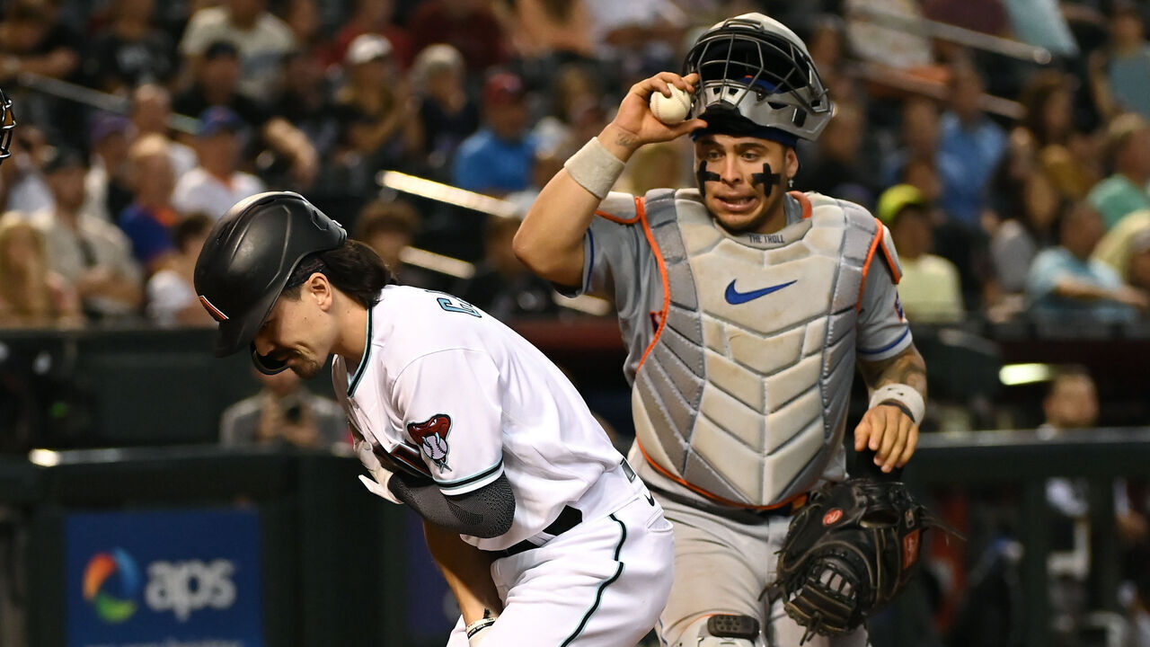 PHOENIX, ARIZONA - JULY 06: Corbin Carroll #7 of the Arizona Diamondbacks holds his arm after a swing as Francisco Alvarez #4 of the New York Mets reacts during the seventh inning at Chase Field on July 06, 2023 in Phoenix, Arizona.