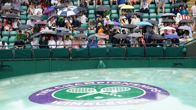 Spectators take shelter during a rain delay on day six of the 2023 Wimbledon Championships at the All England Lawn Tennis and Croquet Club in Wimbledon. Picture date: Saturday July 8, 2023.