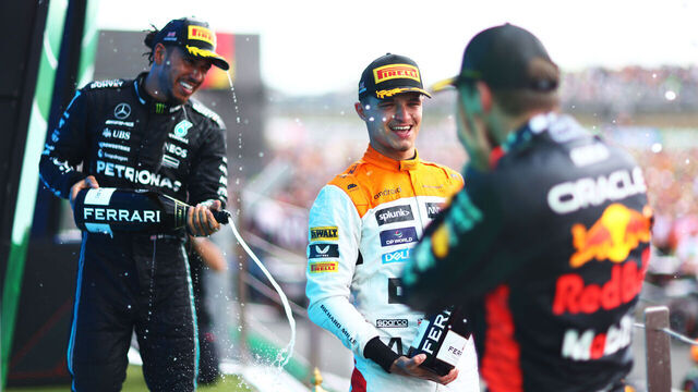 NORTHAMPTON, ENGLAND - JULY 09: Race winner, Max Verstappen of the Netherlands and Oracle Red Bull Racing, Second placed Lando Norris of Great Britain and McLaren celebrates with third placed Lewis Hamilton of Great Britain and Mercedes on the podium during the F1 Grand Prix of Great Britain at Silverstone Circuit on July 09, 2023 in Northampton, England.