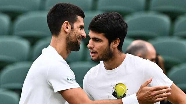 Serbia's Novak Djokovic (L) shakes hands with Spain's Carlos Alcaraz during a practise session prior to their men's singles semi-finals tennis matches on the twelfth day of the 2023 Wimbledon Championships at The All England Lawn Tennis Club in Wimbledon, southwest London, on July 14, 2023.