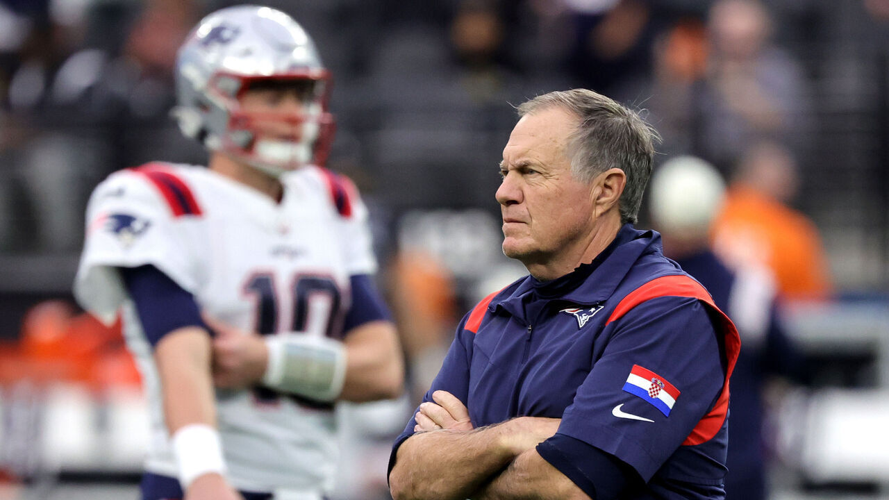 LAS VEGAS, NEVADA - DECEMBER 18: Head coach Bill Belichick of the New England Patriots watches his players, including quarterback Mac Jones #10, warm up before a game against the Las Vegas Raiders at Allegiant Stadium on December 18, 2022 in Las Vegas, Nevada. The Raiders defeated the Patriots 30-24.