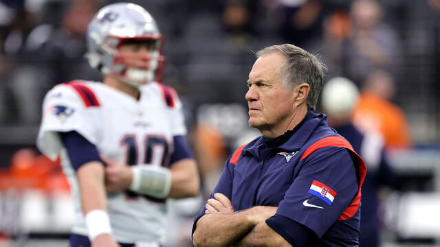 LAS VEGAS, NEVADA - DECEMBER 18: Head coach Bill Belichick of the New England Patriots watches his players, including quarterback Mac Jones #10, warm up before a game against the Las Vegas Raiders at Allegiant Stadium on December 18, 2022 in Las Vegas, Nevada. The Raiders defeated the Patriots 30-24.