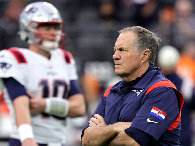 LAS VEGAS, NEVADA - DECEMBER 18: Head coach Bill Belichick of the New England Patriots watches his players, including quarterback Mac Jones #10, warm up before a game against the Las Vegas Raiders at Allegiant Stadium on December 18, 2022 in Las Vegas, Nevada. The Raiders defeated the Patriots 30-24.