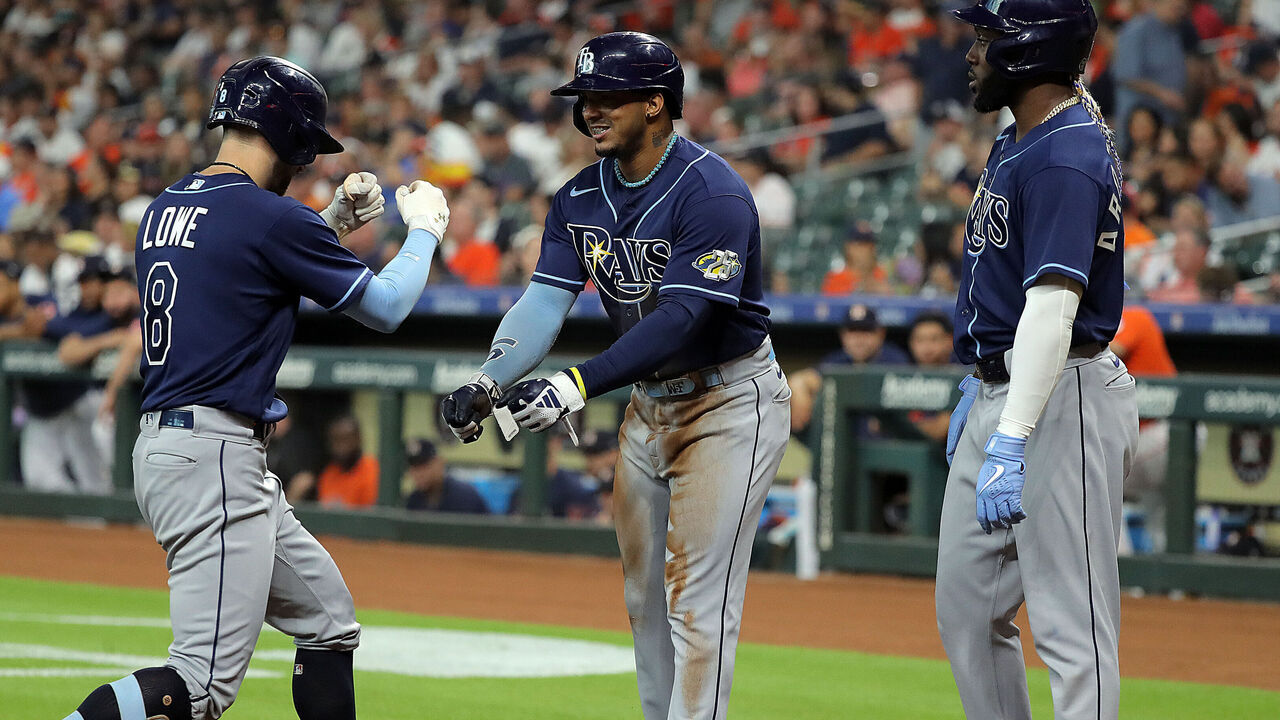HOUSTON, TEXAS - JULY 28: Brandon Lowe (L) #8 of the Tampa Bay Rays is welcomed at home plate by teammates Wander Franco (C) #5 and Randy Arozarena #56 after hitting a home run in the first inning against the Houston Astros at Minute Maid Park on July 28, 2023 in Houston, Texas.