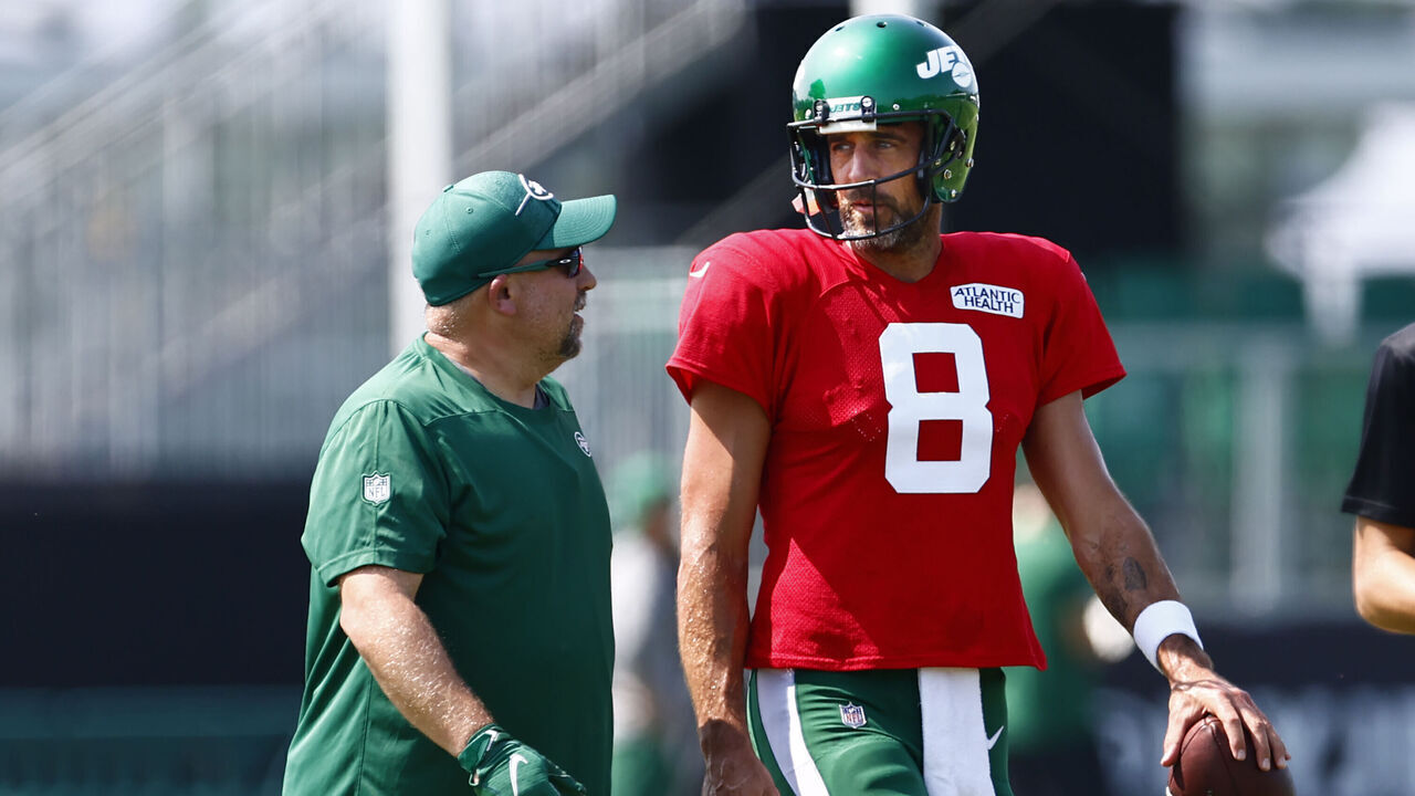 FLORHAM PARK, NEW JERSEY - JULY 26: Quarterback Aaron Rodgers #8 of the New York Jets talks with a coach during training camp at Atlantic Health Jets Training Center on July 26, 2023 in Florham Park, New Jersey.