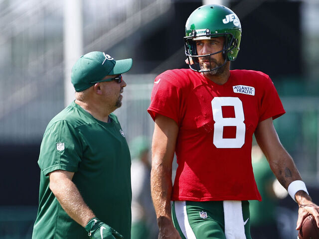 FLORHAM PARK, NEW JERSEY - JULY 26: Quarterback Aaron Rodgers #8 of the New York Jets talks with a coach during training camp at Atlantic Health Jets Training Center on July 26, 2023 in Florham Park, New Jersey.