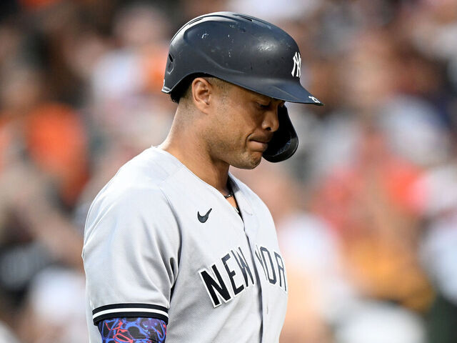 BALTIMORE, MARYLAND - JULY 30: Giancarlo Stanton #27 of the New York Yankees walks to the dugout after striking out in the third inning against the Baltimore Orioles at Oriole Park at Camden Yards on July 30, 2023 in Baltimore, Maryland.