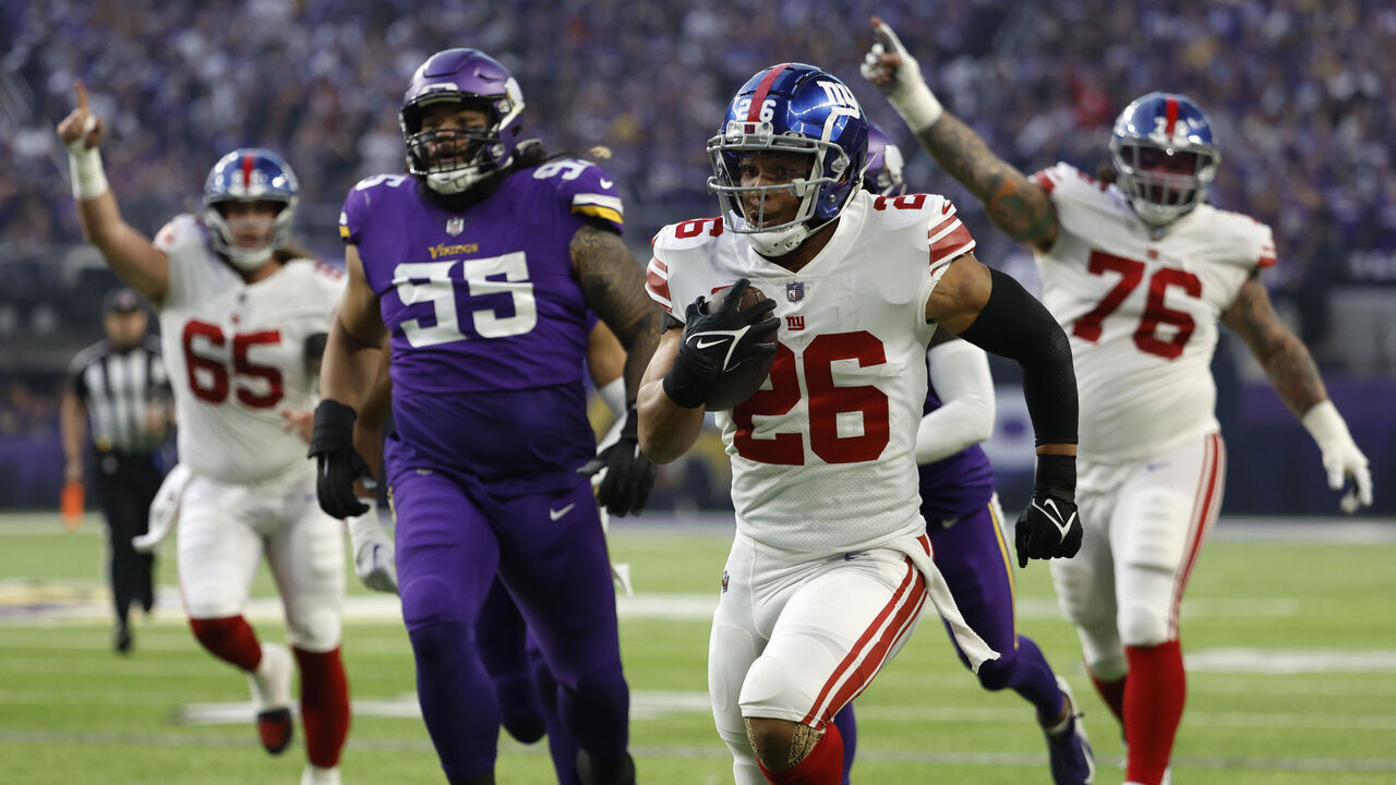 MINNEAPOLIS, MINNESOTA - JANUARY 15: Saquon Barkley #26 of the New York Giants rushes for a touchdown during the first quarter against the Minnesota Vikings in the NFC Wild Card playoff game at U.S. Bank Stadium on January 15, 2023 in Minneapolis, Minnesota.