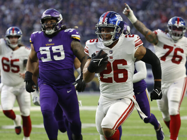MINNEAPOLIS, MINNESOTA - JANUARY 15: Saquon Barkley #26 of the New York Giants rushes for a touchdown during the first quarter against the Minnesota Vikings in the NFC Wild Card playoff game at U.S. Bank Stadium on January 15, 2023 in Minneapolis, Minnesota.
