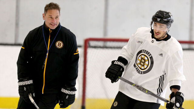 BOSTON - APRIL 10: Boston Bruins head coach Bruce Cassidy, left, and player #63 Brad Marchand skate during Bruins practice at Warrior Arena in the Brighton neighborhood of Boston on April 10, 2018.