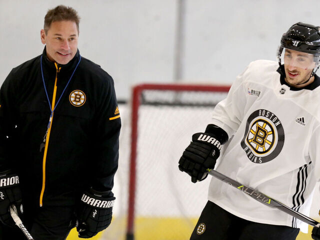 BOSTON - APRIL 10: Boston Bruins head coach Bruce Cassidy, left, and player #63 Brad Marchand skate during Bruins practice at Warrior Arena in the Brighton neighborhood of Boston on April 10, 2018.