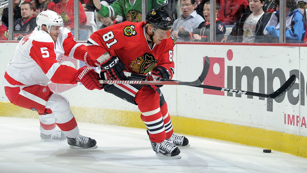 CHICAGO, IL- DECEMBER 30: Marian Hossa #81 of the Chicago Blackhawks and Nicklas Lidstrom #5 of the Detroit Red Wings approach the puck by the boards during the NHL game on December 30, 2011 at the United Center in Chicago, Illinois.