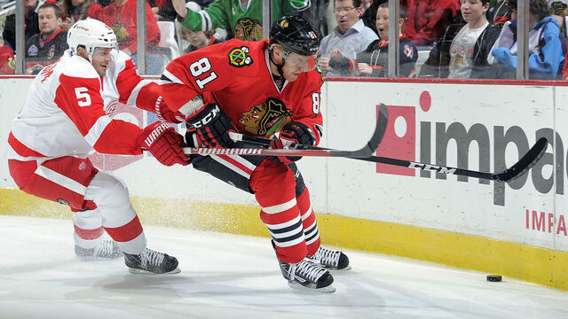 CHICAGO, IL- DECEMBER 30: Marian Hossa #81 of the Chicago Blackhawks and Nicklas Lidstrom #5 of the Detroit Red Wings approach the puck by the boards during the NHL game on December 30, 2011 at the United Center in Chicago, Illinois.