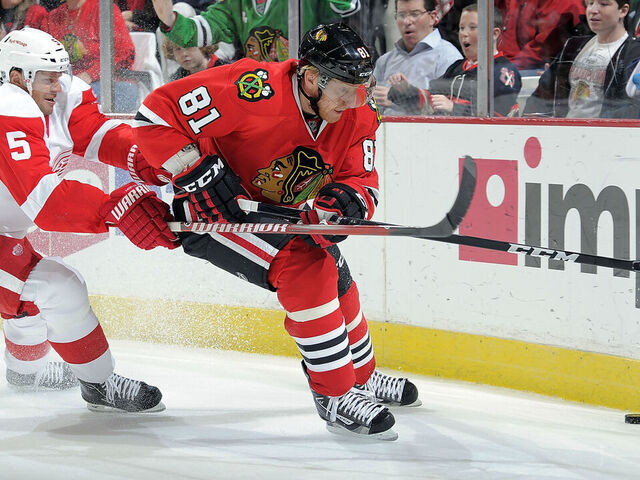 CHICAGO, IL- DECEMBER 30: Marian Hossa #81 of the Chicago Blackhawks and Nicklas Lidstrom #5 of the Detroit Red Wings approach the puck by the boards during the NHL game on December 30, 2011 at the United Center in Chicago, Illinois.