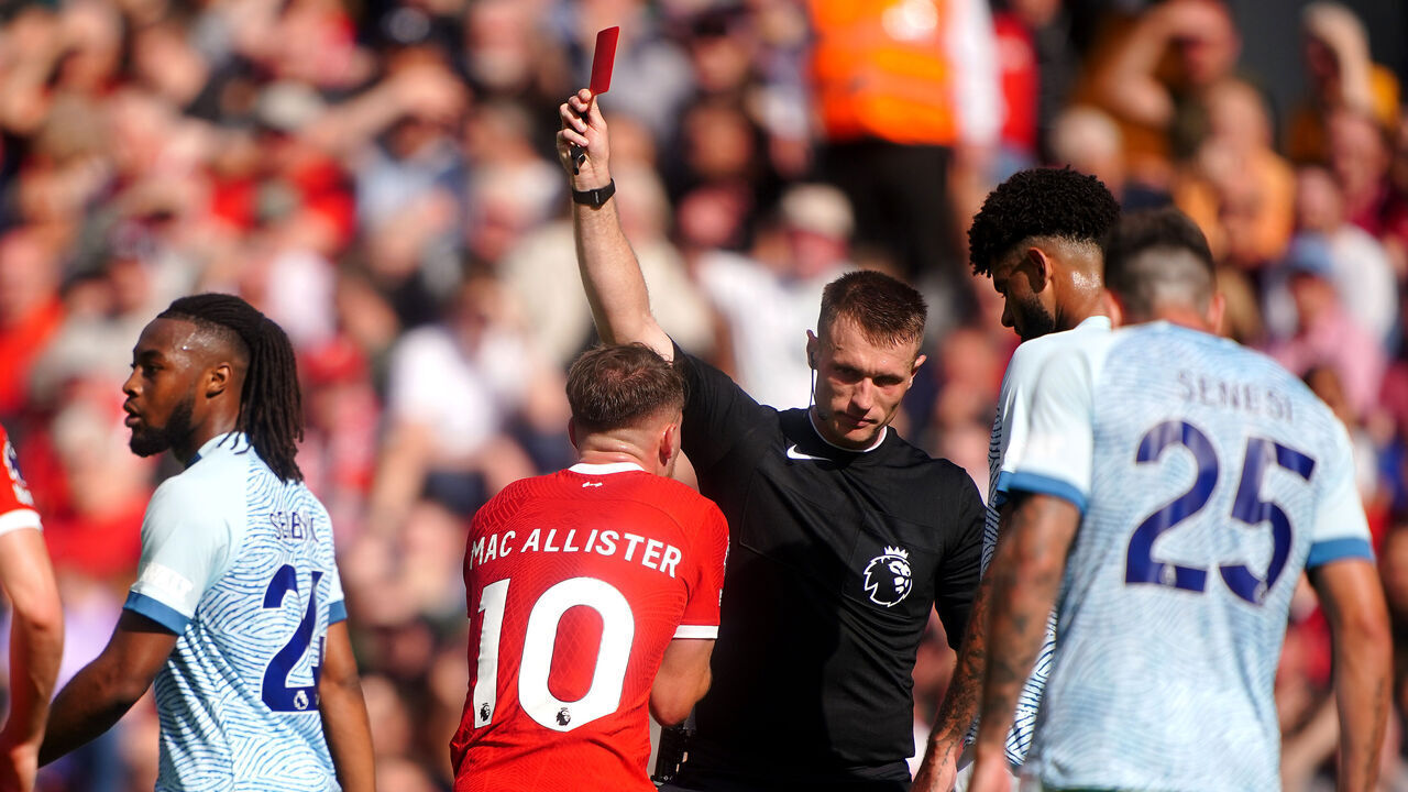 Referee Thomas Bramall shows a red card to Liverpool's Alexis Mac Allister for serious foul play during the Premier League match at Anfield, Liverpool. Picture date: Saturday August 19, 2023.