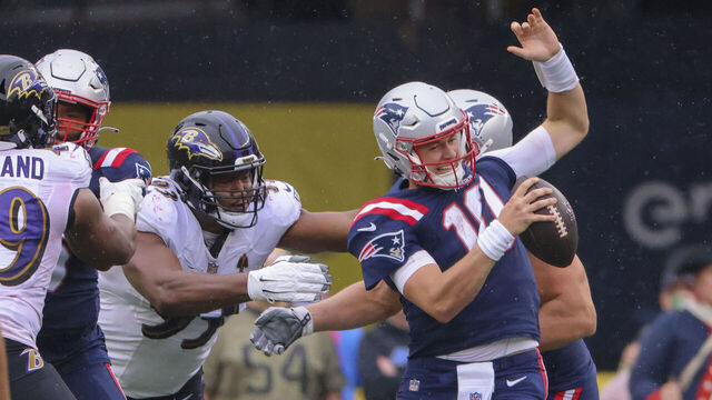 Foxborough, MA - September 25: New England Patriots QB Mac Jones avoids the rush from Baltimore Ravens Calais Campbell. The Patriots lost to the Ravens, 37-26.