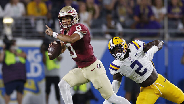 ORLANDO, FL - SEPTEMBER 03: Florida State Seminoles quarterback Jordan Travis (13) looks to pass while under pressure from LSU Tigers defensive end Ovie Oghoufo (2) during a college football game on September 03, 2023 at Camping World Stadium in Orlando, Florida.