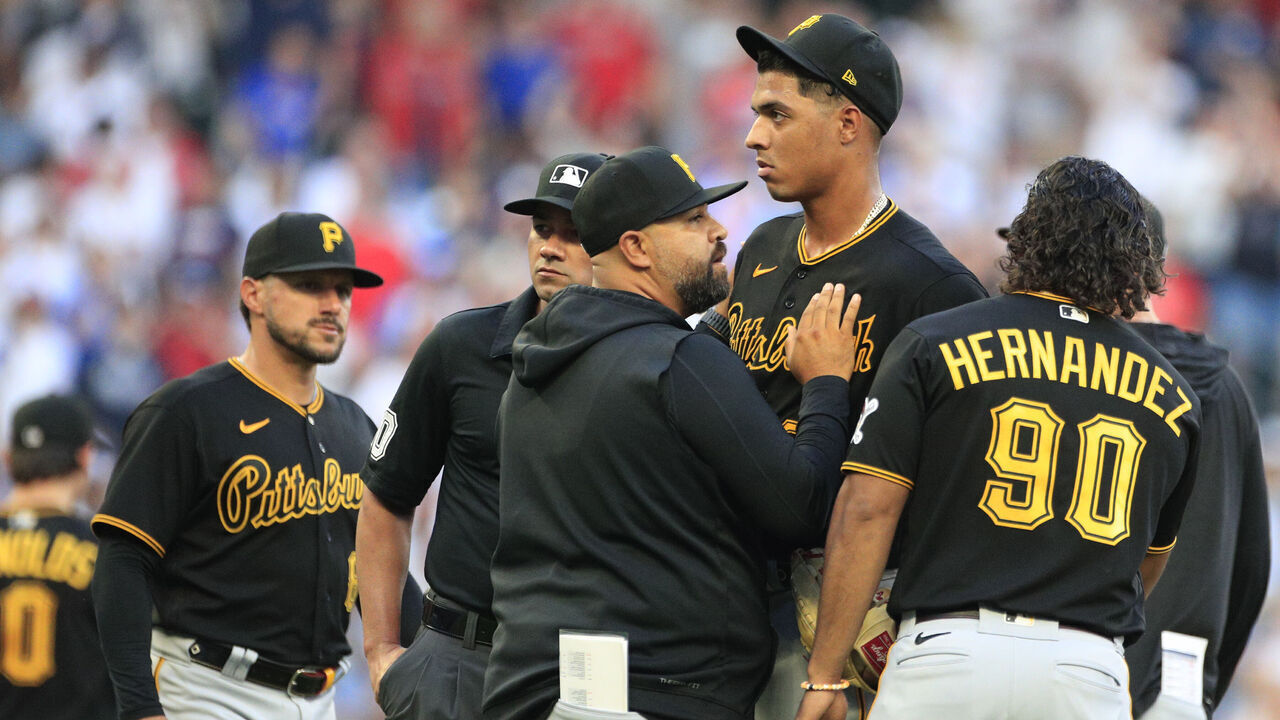 ATLANTA, GA - SEPTEMBER 09: A member of the coaching staff holds back Pittsburgh Pirates starting pitcher Johan Oviedo #24 during the MLB game between the Pittsburg Pirates and the Atlanta Braves on September 09, 2023 at TRUIST Park in Atlanta, GA.