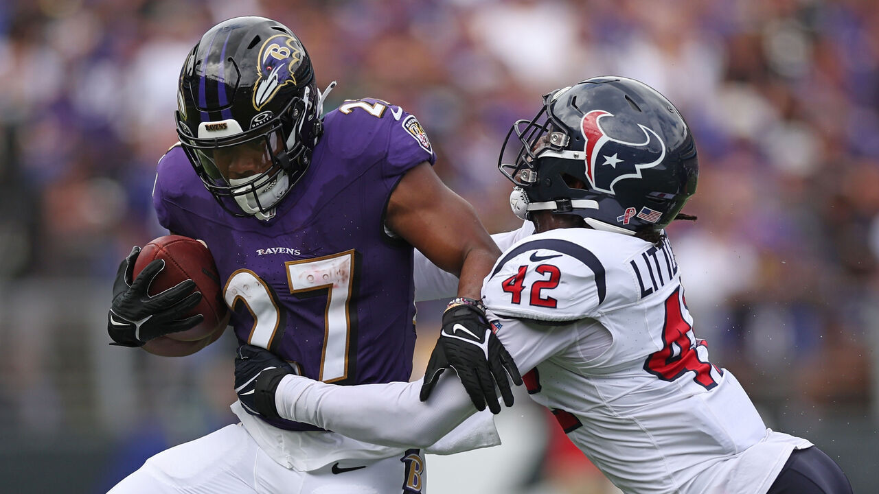 BALTIMORE, MARYLAND - SEPTEMBER 10: J.K. Dobbins #27 of the Baltimore Ravens is wrapped up by Cory Littleton #42 of the Houston Texans during the first half at M&T Bank Stadium on September 10, 2023 in Baltimore, Maryland.