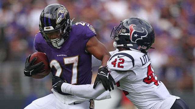 BALTIMORE, MARYLAND - SEPTEMBER 10: J.K. Dobbins #27 of the Baltimore Ravens is wrapped up by Cory Littleton #42 of the Houston Texans during the first half at M&T Bank Stadium on September 10, 2023 in Baltimore, Maryland.