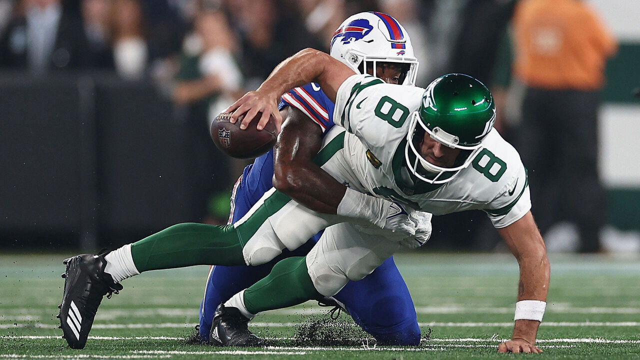 EAST RUTHERFORD, NEW JERSEY - SEPTEMBER 11: Quarterback Aaron Rodgers #8 of the New York Jets sacked by defensive end Leonard Floyd #56 of the Buffalo Bills during the first quarter of the NFL game at MetLife Stadium on September 11, 2023 in East Rutherford, New Jersey.