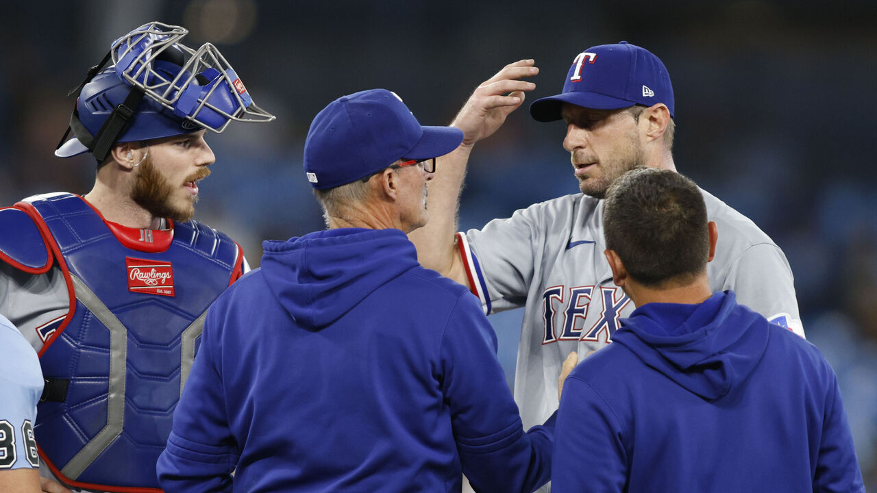 TORONTO, CANADA - SEPTEMBER 12: Max Scherzer #31 of the Texas Rangers meets with trainers and coaches on the mound before leaving the game in the sixth inning against the Toronto Blue Jays at Rogers Centre on September 12, 2023 in Toronto, Canada.