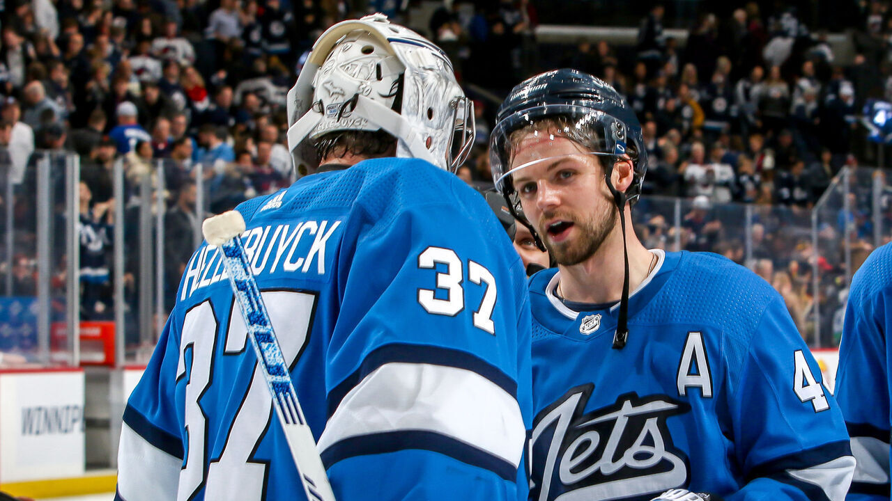 WINNIPEG, MB - JANUARY 14: Goaltender Connor Hellebuyck #37 of the Winnipeg Jets gets congratulated by teammate Josh Morrissey #44 following a 4-0 shutout over the Vancouver Canucks at the Bell MTS Place on January 14, 2020 in Winnipeg, Manitoba, Canada.