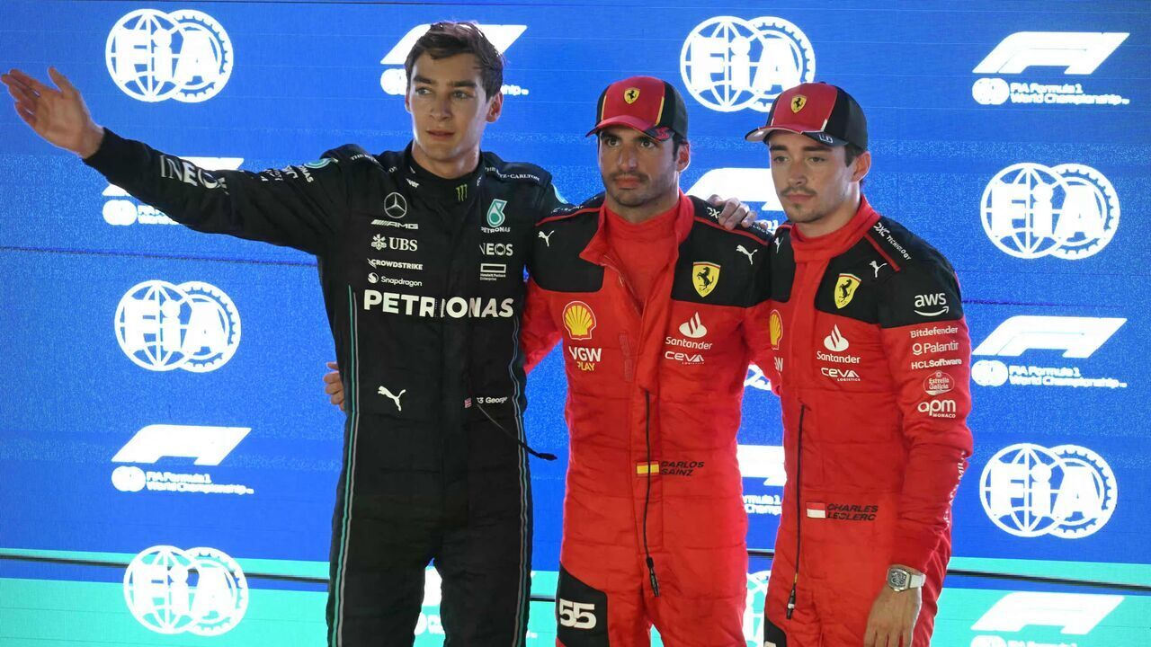 Mercedes' British driver George Russell (L), Ferrari's Spanish driver Carlos Sainz Jr (C) and Ferrari's Monegasque driver Charles Leclerc (R) pose for photos after the qualifying session of the Singapore Formula One Grand Prix night race at the Marina Bay Street Circuit in Singapore on September 16, 2023.