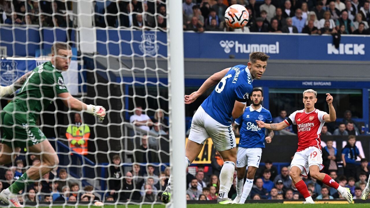 Arsenal's Belgian midfielder #19 Leandro Trossard (R) watches as his shot beats Everton's English goalkeeper #01 Jordan Pickford (L) for the opening goal of the English Premier League football match between Everton and Arsenal at Goodison Park in Liverpool, north west England on September 17, 2023.