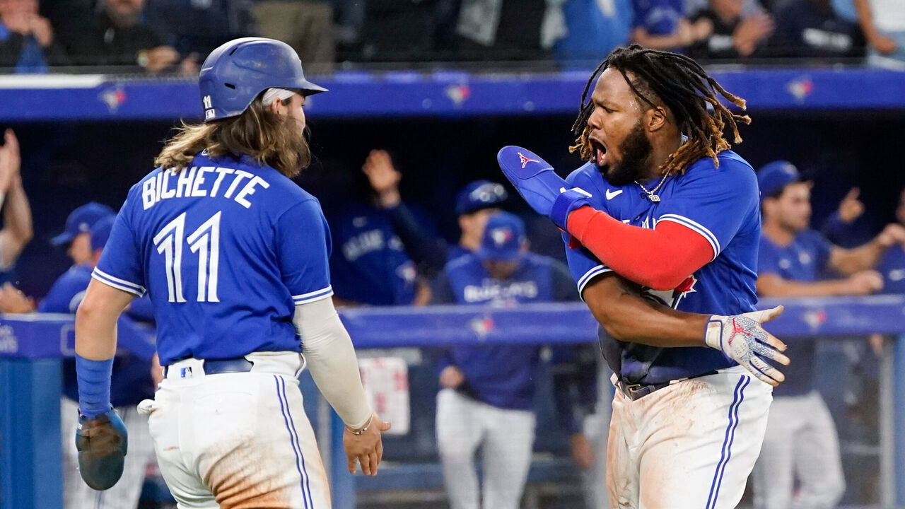 TORONTO, - SEPTEMBER 26: Vladimir Guerrero Jr. #27 of the Toronto Blue Jays high-fives Bo Bichette #11 after scoring in the fourth inning during the game between the New York Yankees and the Toronto Blue Jays at Rogers Centre on Monday, September 26, 2022 in Toronto, Canada.