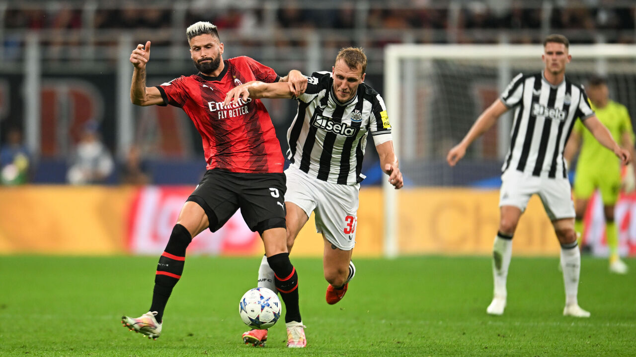 MILAN, ITALY - SEPTEMBER 19: Dan Burn of Newcastle United (33) and Olivier Giroud of AC Milan (9) jostle for the ballduring the UEFA Champions League match between AC Milan and Newcastle United at Stadio Giuseppe Meazza on September 19, 2023 in Milan, Italy.