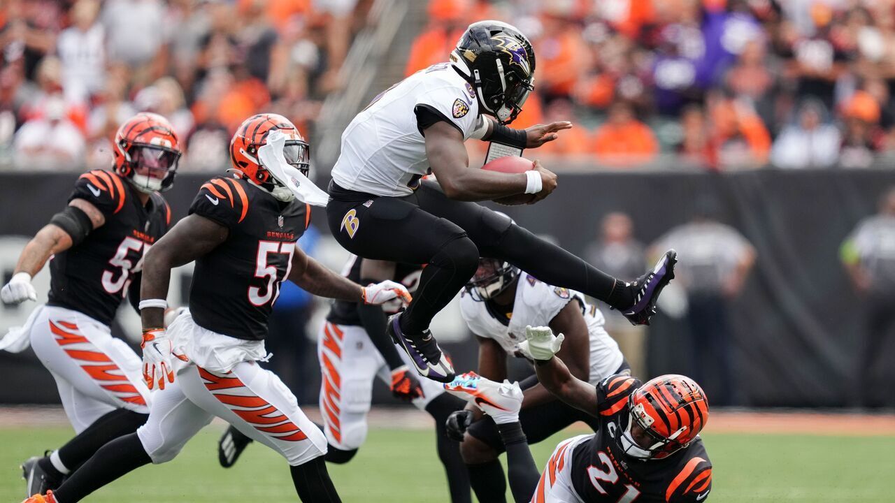 CINCINNATI, OHIO - SEPTEMBER 17: Lamar Jackson #8 of the Baltimore Ravens leaps over Mike Hilton #21 of the Cincinnati Bengals while running with the ball in the second quarter at Paycor Stadium on September 17, 2023 in Cincinnati, Ohio.
