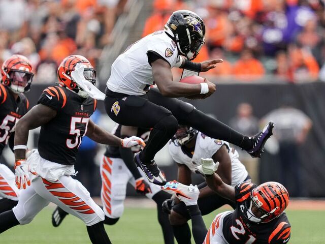 CINCINNATI, OHIO - SEPTEMBER 17: Lamar Jackson #8 of the Baltimore Ravens leaps over Mike Hilton #21 of the Cincinnati Bengals while running with the ball in the second quarter at Paycor Stadium on September 17, 2023 in Cincinnati, Ohio.