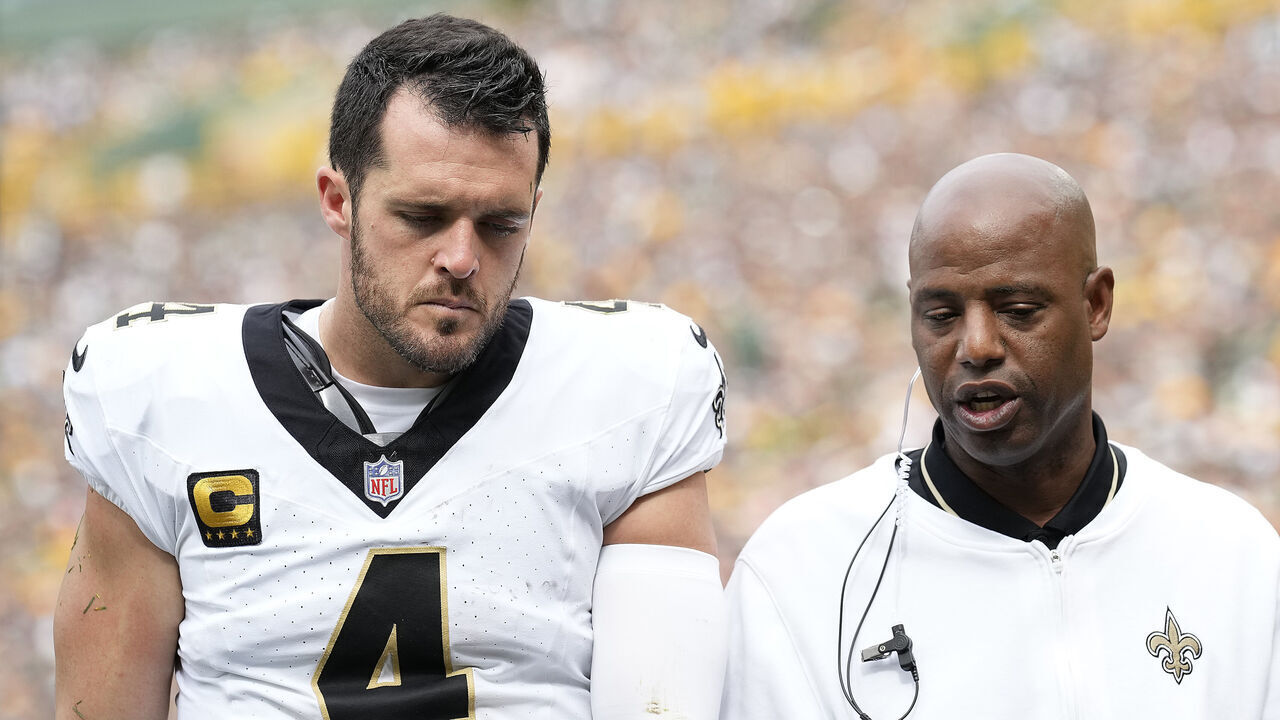 GREEN BAY, WISCONSIN - SEPTEMBER 24: New Orleans Saints staff walk off with Derek Carr #4 of the New Orleans Saints to the locker room during the third quarter against the Green Bay Packers at Lambeau Field on September 24, 2023 in Green Bay, Wisconsin.