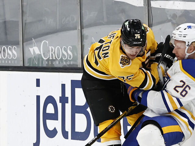 BOSTON, MA - MARCH 27: Boston Bruins defenseman Connor Clifton (75) hits Buffalo Sabres defenseman Rasmus Dahlin (26) during a game between the Boston Bruins and the Buffalo Sabres on March 27, 2021, at TD Garden in Boston, Massachusetts.
