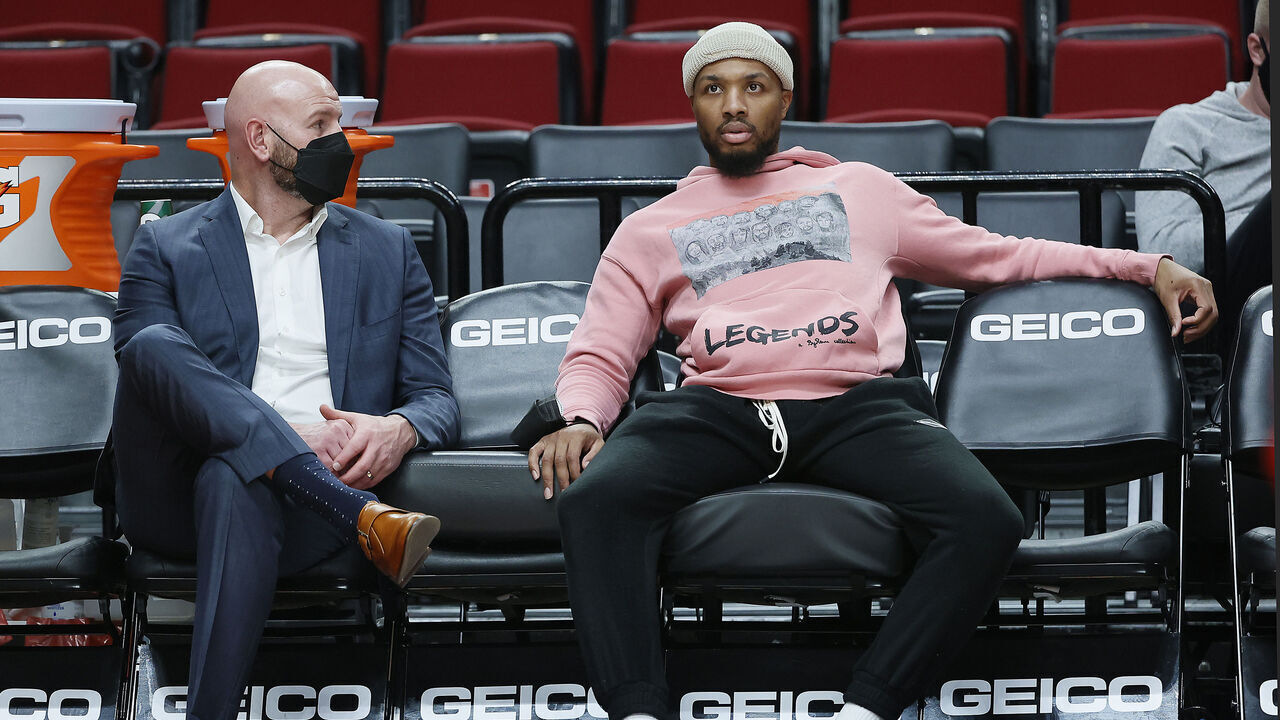 PORTLAND, OREGON - JANUARY 05: Damian Lillard #0 of the Portland Trail Blazers talks with interim General Manager Joe Cronin before the game against the Miami Heat at Moda Center on January 05, 2022 in Portland, Oregon.