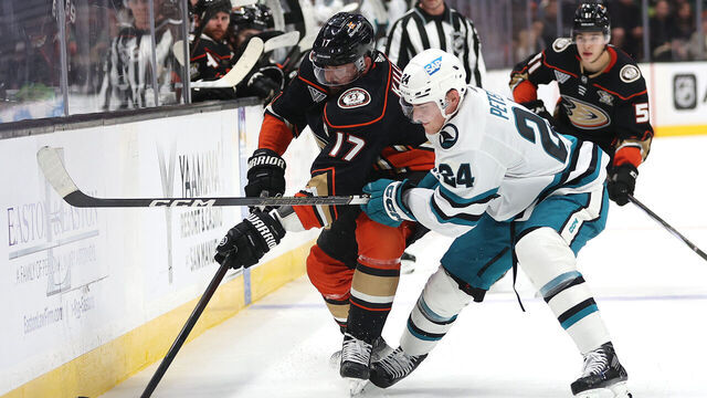 ANAHEIM, CALIFORNIA - SEPTEMBER 27: Alex Killorn #17 of the Anaheim Ducks controls the puck past the defense of Jacob Peterson #24 of the San Jose Sharks during the second period of a preseason game at Honda Center on September 27, 2023 in Anaheim, California.