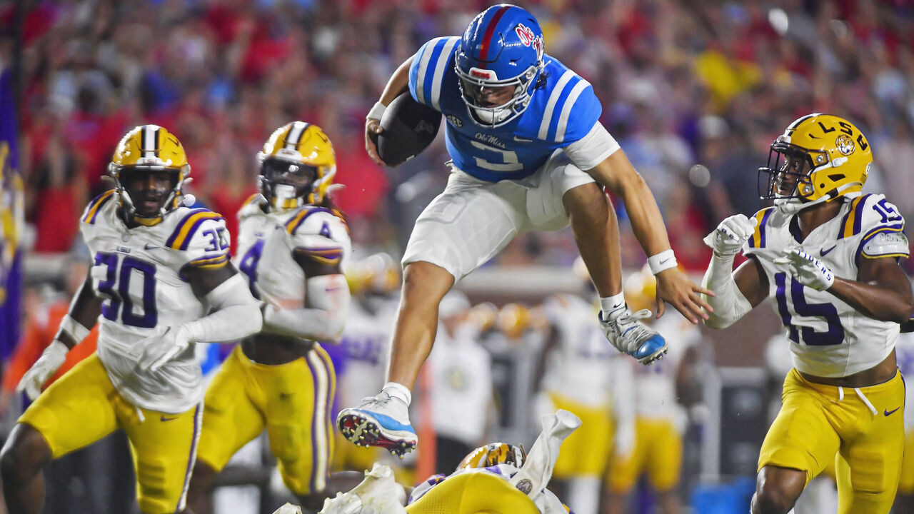 OXFORD, MS - SEPTEMBER 30: Mississippi Rebels quarterback Jaxson Dart leaps over a LSU Tigers defender during the third quarter of a college football game between the LSU Tigers and Mississippi Rebels on Saturday, September 30, 2023 at Vaught-Hemingway Stadium in Oxford, MS.
