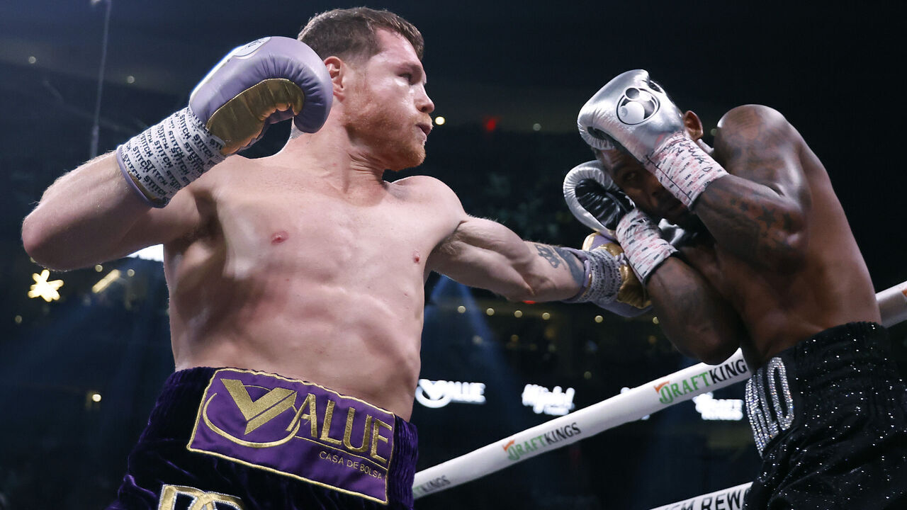LAS VEGAS, NEVADA - SEPTEMBER 30: Saul "Canelo" Alvarez of Mexico (purple/gold trunks) trades punches with Jermell Charlo (black trunks) during their super middleweight title fight at T-Mobile Arena on September 30, 2023 in Las Vegas, Nevada.