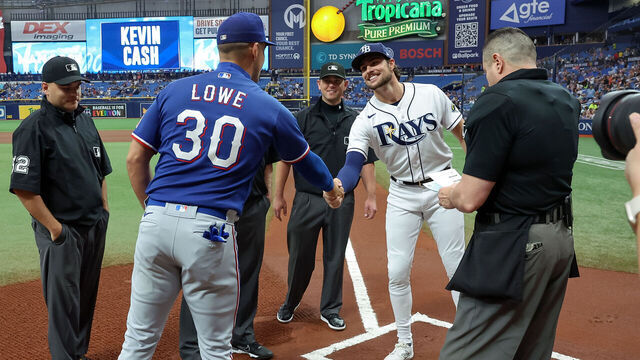 ST. PETERSBURG, FL - JUNE 10: Nathaniel Lowe (L) #30 of the Texas Rangers and his brother Josh Lowe (R) #15 of the Tampa Bay Rays exchange lineup cards prior to a baseball game at Tropicana Field on June 10, 2023 in St. Petersburg, Florida.